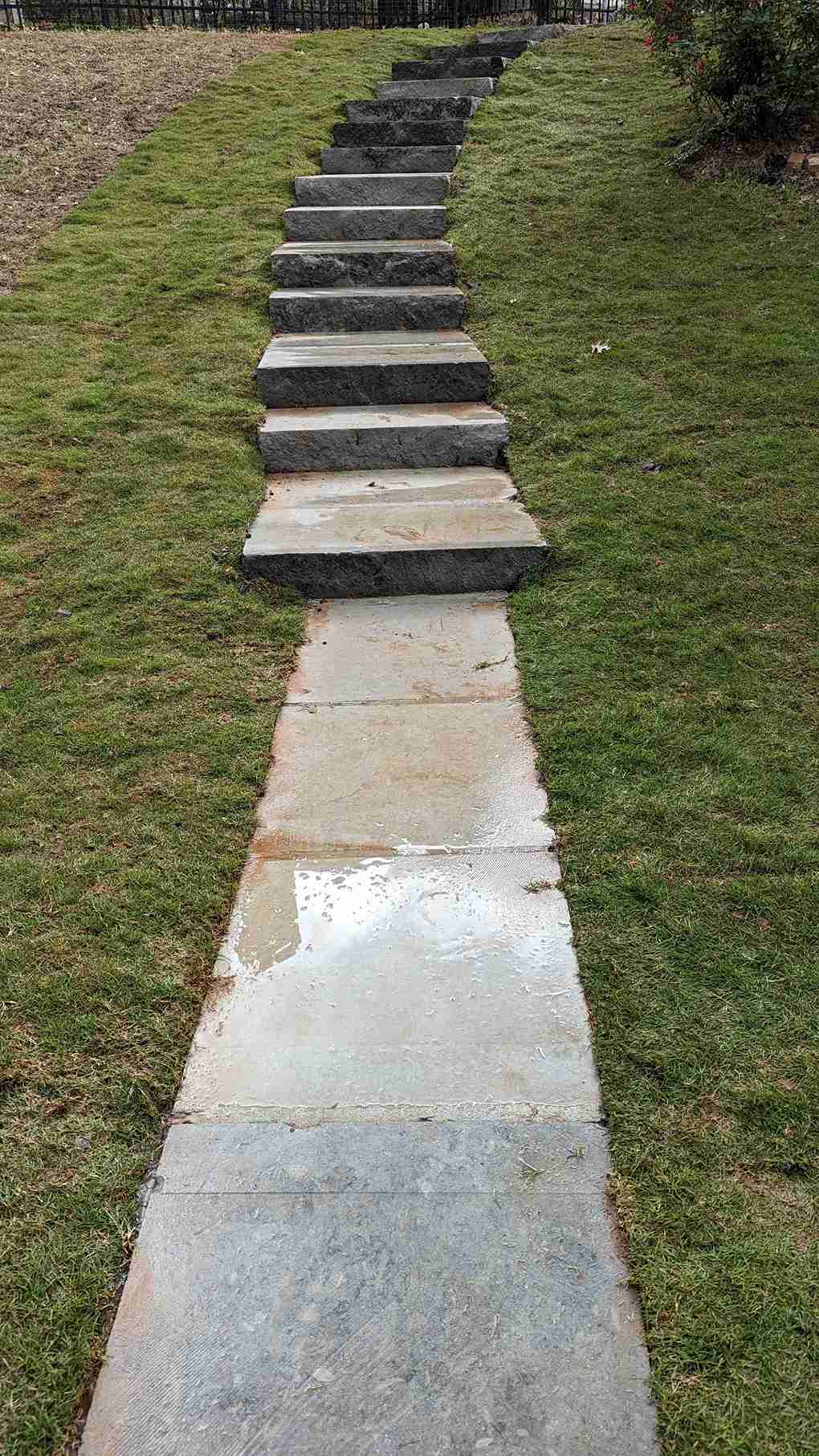 Granite block steps and flagstone landings climbing a lawn slope