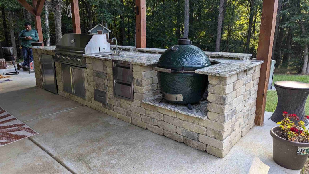 Covered outdoor living space with a stone fireplace